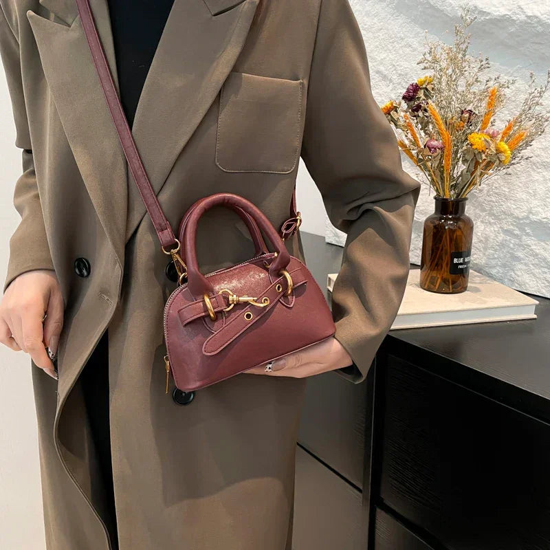 Mała skórzana torebka z ozdobnym paskiem