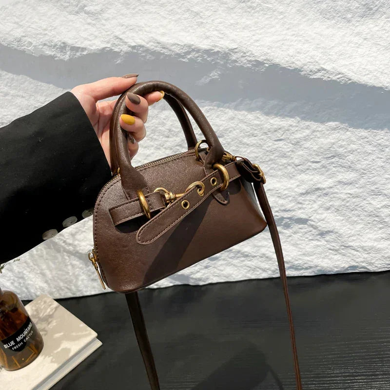 Mała skórzana torebka z ozdobnym paskiem